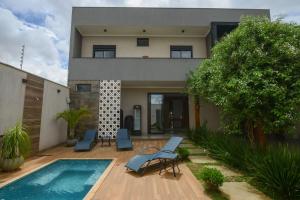 a house with a swimming pool in front of it at Casa com Piscina Aquecida Churrasqueira e Hidro in Franca