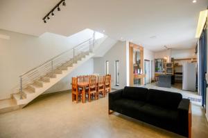 a living room with a black couch and a staircase at Casa com Piscina Aquecida Churrasqueira e Hidro in Franca