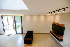 a living room with a black couch and a flat screen tv at Casa com Piscina Aquecida Churrasqueira e Hidro in Franca +37 photos
