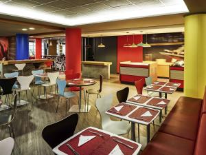 a restaurant with tables and chairs and a kitchen at ibis Sao Paulo Morumbi in São Paulo