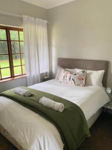 a bedroom with a bed with two towels on it at Foundry farmhouse in Bothaʼs Hill