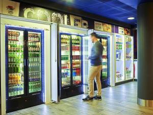 a man is standing in front of a refrigerator at ibis budget Birmingham Centre in Birmingham