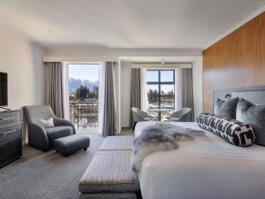 a hotel room with a bed and a large window at Sofitel Queenstown Hotel & Spa in Queenstown +183 photos