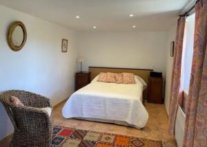 a bedroom with a bed and a chair at Le verger in Vébron