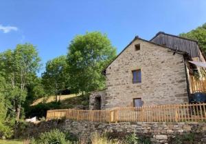 an old stone house with a wooden fence around it at Le verger in Vébron