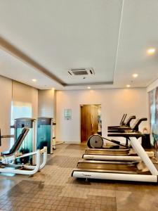 a gym with several treadmills and elliptical machines at Saint Honore Executive 1 Full bed, 1 Sofa bed 1 Pull out bed 2BR in Iloilo City