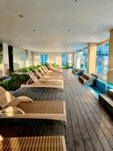 a row of benches in a building with windows at Saint Honore Executive 1 Full bed, 1 Sofa bed 1 Pull out bed 2BR in Iloilo City