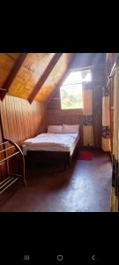 a small bed in a room with a window at Ohiya Our Time Kabana in Ohiya