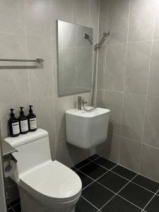 a bathroom with a white toilet and a mirror at momohouse 체스룸 in Chinyŏng-yŏk