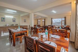 a dining room with wooden tables and chairs at Treebo Melag Jispa With Mountain View in Jispa