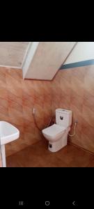 a bathroom with a toilet and a sink at Ohiya Our Time Kabana in Ohiya