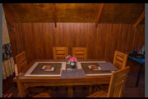 a wooden table with chairs and a vase with flowers on it at Ohiya Our Time Kabana in Ohiya +6 photos