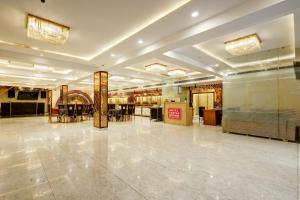a large room with a lobby with tables and chairs at Castle Grand Dwarka in New Delhi