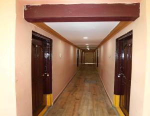 an empty hallway with two doors and wooden floors at Spot On V GUST IN in Tenāli
