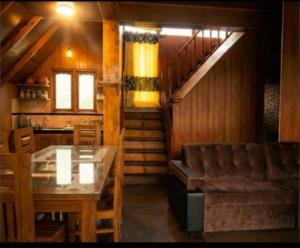 a dining room with a table and a staircase at Ohiya Our Time Kabana in Ohiya