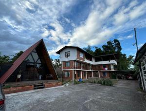 a large brick building with a gambrel roof at DEPARTAMENTO ENCANTO AMAZÓNICO Macas in Macas