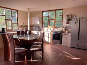 a kitchen with a table with chairs and a refrigerator at DEPARTAMENTO ENCANTO AMAZÓNICO Macas in Macas