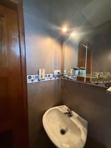 a bathroom with a sink and a mirror at DEPARTAMENTO ENCANTO AMAZÓNICO Macas in Macas +22 photos