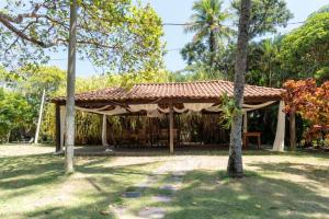 a pavilion with a table and trees in a park at Chacara Morada do Sol com Piscina e Churrasqueira in Sepetiba