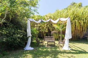 a white gazebo with chairs and a table at Chacara Morada do Sol com Piscina e Churrasqueira in Sepetiba