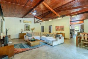 a living room with a couch and a table at Chacara Morada do Sol com Piscina e Churrasqueira in Sepetiba