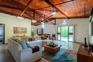 a living room with a large couch and a table at Chacara Morada do Sol com Piscina e Churrasqueira in Sepetiba +33 photos