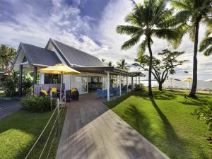 a house with a patio and a lawn with palm trees at Sofitel Fiji Resort & Spa in Denarau
