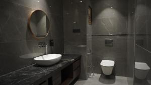 a bathroom with a sink and a mirror and a toilet at The LEGACY HOTEL JAMSHEDPUR in Jamshedpur