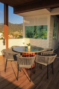 a patio with a table and chairs and a window at Monbelt Luxury Apartment with Rooftop Jacuzzi in Puerto Vallarta