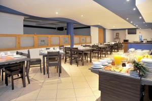 a dining room with tables and chairs in a restaurant at Hotel del Principado Durango in Durango
