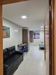 a living room with a couch and a table at Flat Macambira Home Service in Campina Grande +1 photo