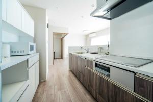 a kitchen with white counters and wooden cabinets at Formosa Hills in Kumamoto