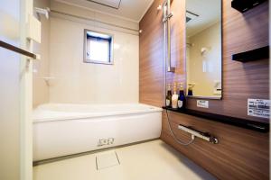 a bathroom with a tub and a sink at Formosa Hills in Kumamoto