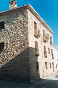un grand bâtiment en briques avec une grande ombre dans l'établissement Casa Hipolito, à Corduente