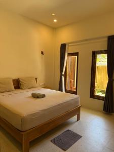a bedroom with a large bed with a window at Mango Room Mandalika in Kuta Lombok