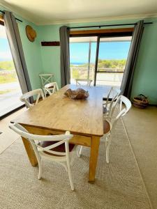 a dining room table with chairs and a large window at Ocean Whisper in Island Beach