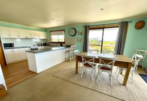 a kitchen with a table and a table and chairs at Ocean Whisper in Island Beach