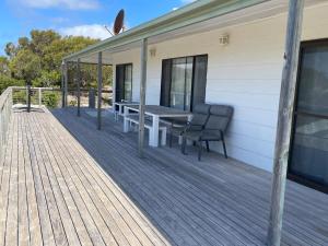 a wooden deck with a bench on a house at Ocean Whisper in Island Beach