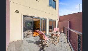 a patio with two chairs and a table on a balcony at Convenience & Luxury Apartment in Melbourne