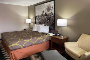 a small hotel room with a bed and a chair at Red Lion Inn & Suites Junction City in Junction City