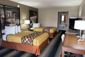 a hotel room with two beds and a desk at Red Lion Inn & Suites Junction City in Junction City