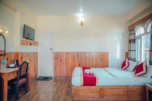 a bedroom with a large bed with a desk and a desk at Hotel KR Mandap in Pokhara