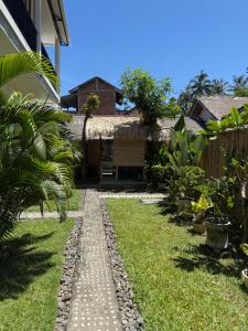 a garden with a pathway leading to a house at Mango Room Mandalika in Kuta Lombok