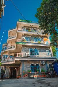 a tall building with blue windows on a street at Hotel KR Mandap in Pokhara