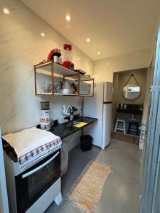 a small kitchen with a counter and a refrigerator at Pousada - Aconchego da tia Zeni in Mangaratiba