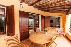 トッレ・デッレ・ステッレにあるHoliday home in Torre delle Stelle 22921の木製テーブルと椅子付きのパティオ