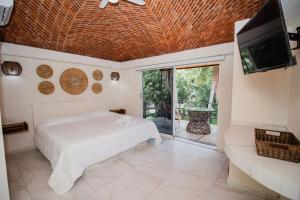 a bedroom with a bed and a tv and a couch at Paulas Suites Terraza in Ixtapa