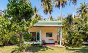 a house with palm trees in front of it at Green Heaven Bungalows in Ban Bang Po