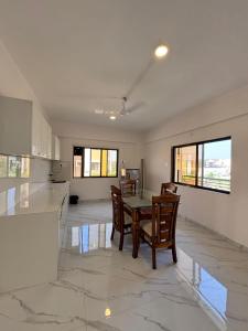 a kitchen and dining room with a table and chairs at Villa 37 in Dhamni
