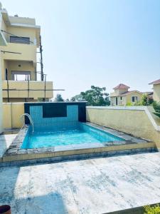 a swimming pool in front of a house at Villa 37 in Dhamni